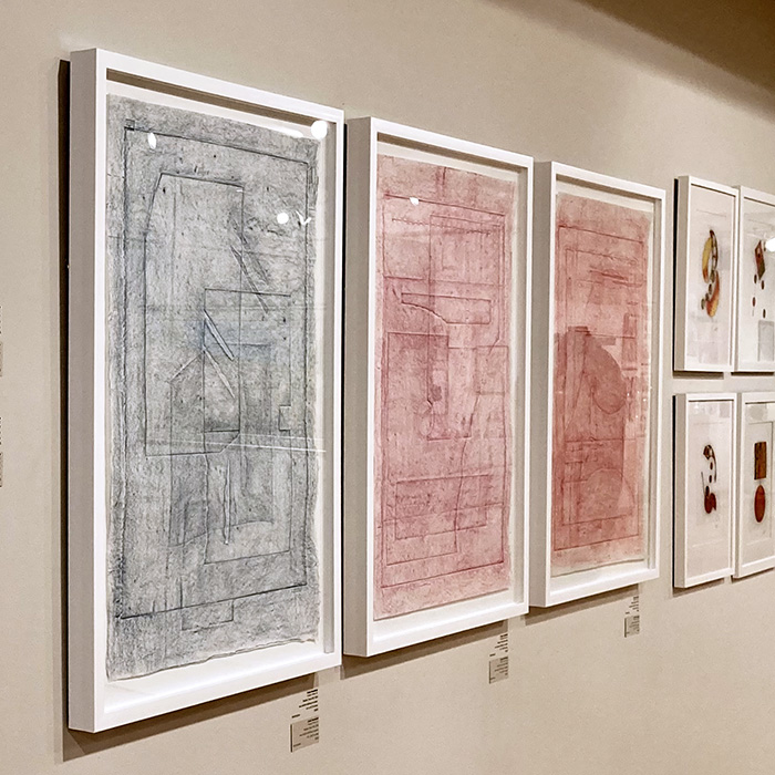 Three rubbings from Reality Check series on a gallery wall.